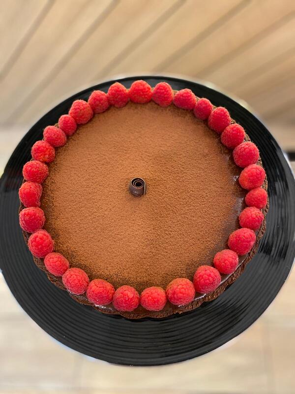 Dark Chocolate Tart decorated with a ring of raspberries 